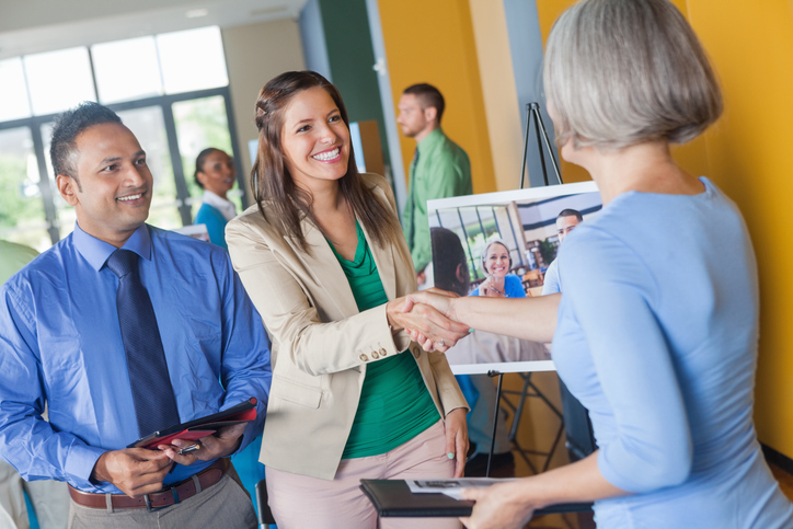 Students at a busy career fair shaking hands