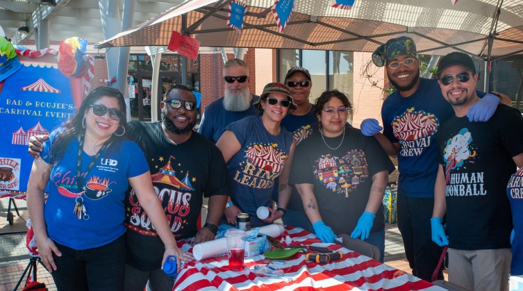 A group of people stands together smiling at the chili cook-off event.