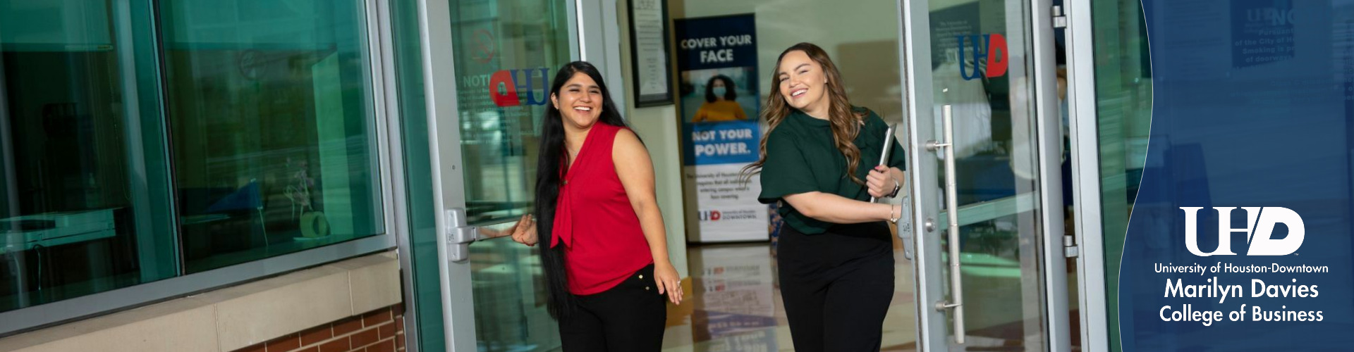 two female students exiting building