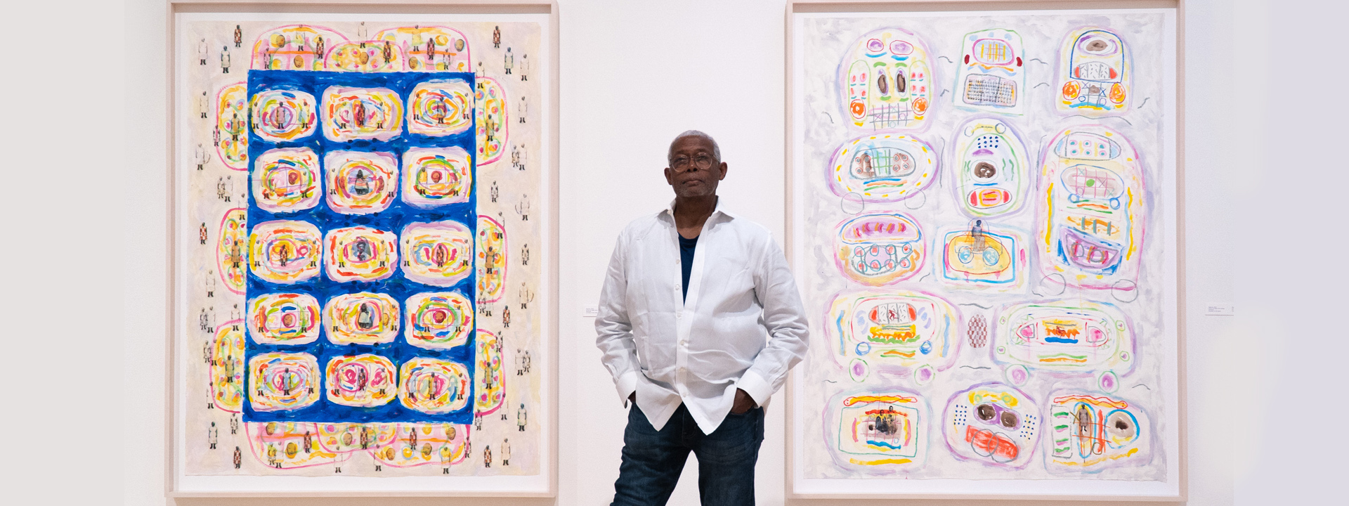 Floyd Newsum standing in front of his art pieces