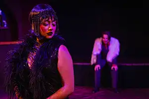 female charater glances back at male actor