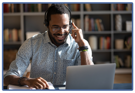 smiling man with headset at laptop computer