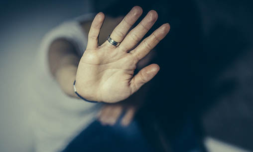 Woman with her hand out to defend herself