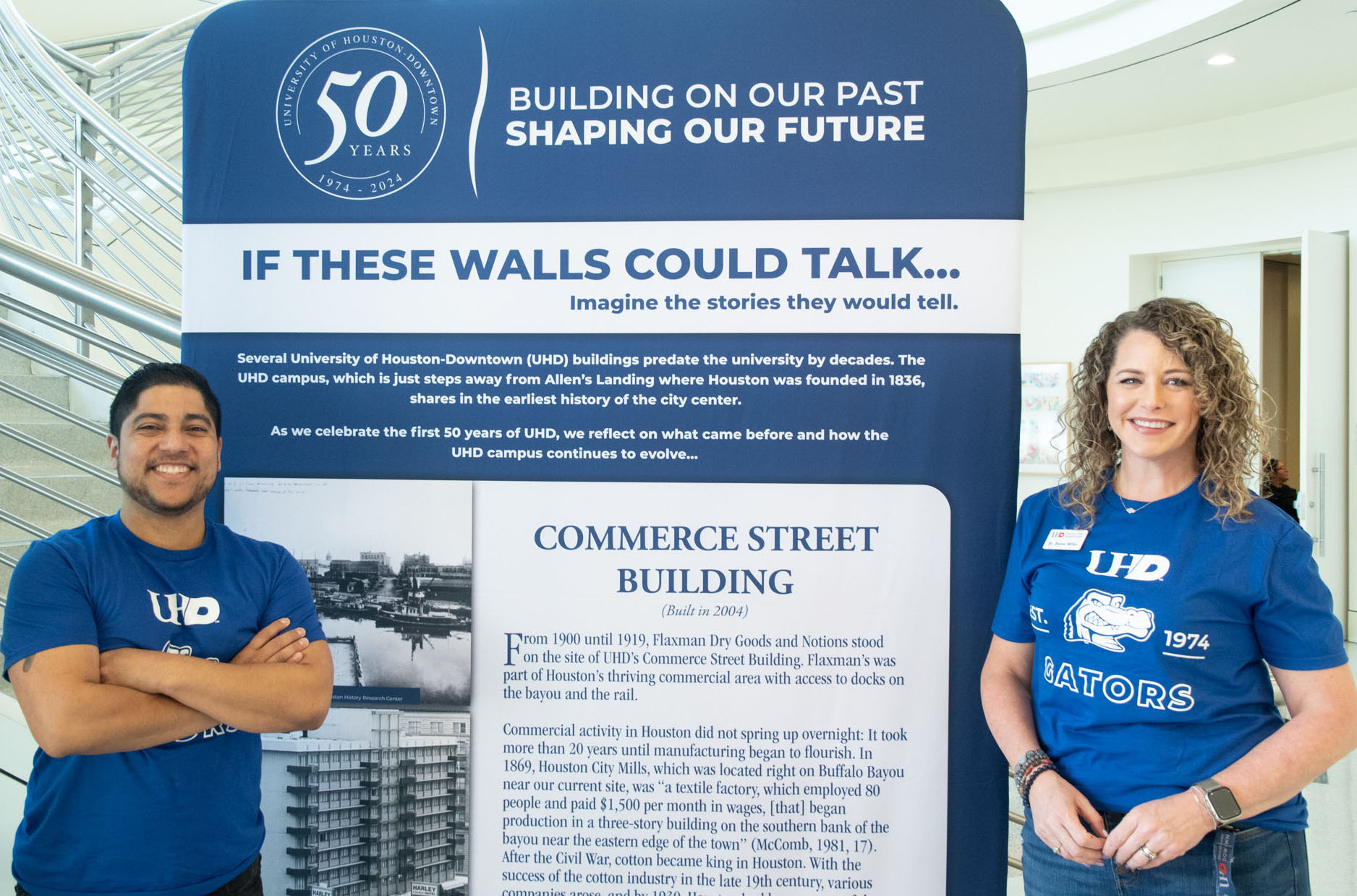 Two Staff of the College of Public Service standing next to the Commerce Building History