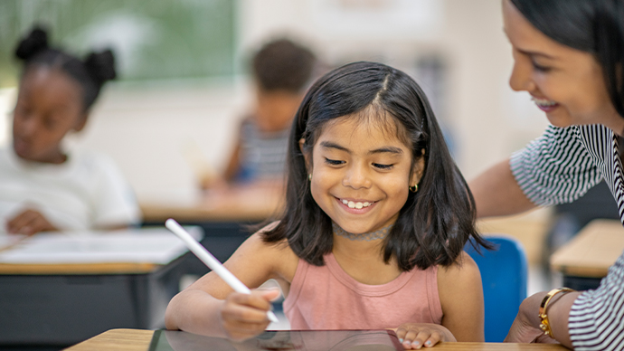 profesora con estudiante en el escritorio