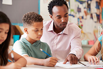 male teacher high-fiving student in classroom