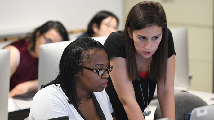 Teacher helping out student at their computer