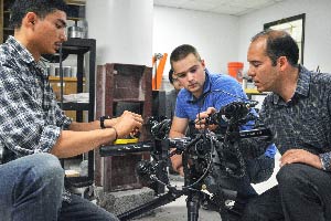 Three men looking at electronic equipment