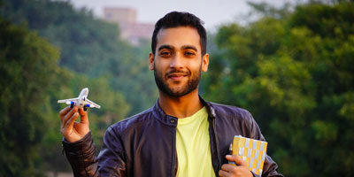 College student holding a small airplane