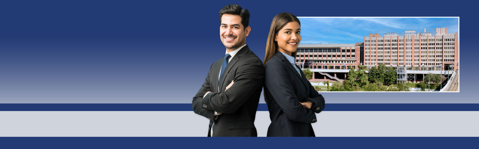 Graduate students in suit standing back to back, uhd one main building in background