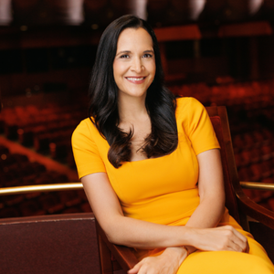 Khori Dastoor wears a yellow dress and smiles