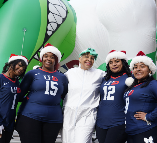 Members of the womens volleyball team stand with University Relations Assistant Vice President Debra McGaughey