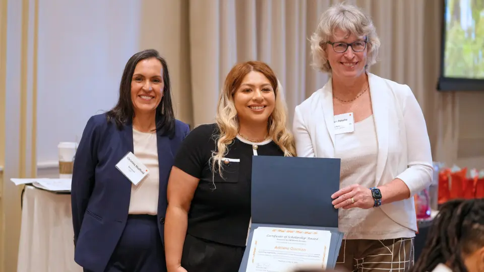 Adriana Guzman a University of Houston-Downtown student smiles aside two adults in the Society of Information Management Women at an awards ceremony. Guzman is the recipient of the 2026 SIM Women Scholarship. 
