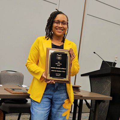 Kionna Walker LeMalle Director of Executive Communications for university of houston-downtown holds her book Behind the waterline