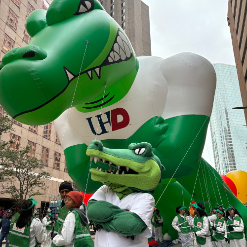 An Ed-U-Gator parade float and Ed-U-Gator the University of Houston-Downtown mascot in Downtown Houston at the H-E-B Thanksgiving Day Parade. 