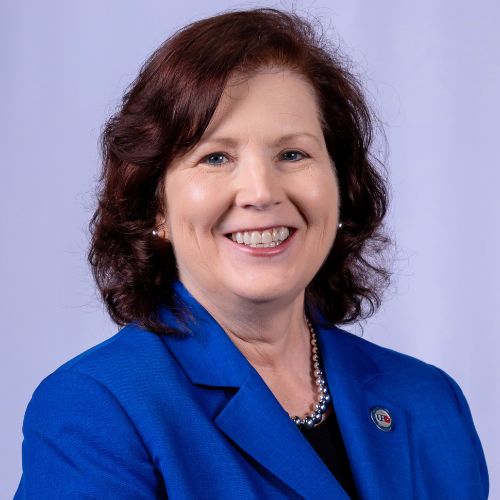 Deborah Bordelon smiles while wearing a University of Houston Downtown pin and blue blazer. Bordelon is Provost and Senior Vice President for Academic Affairs at University of Houston Downtown.