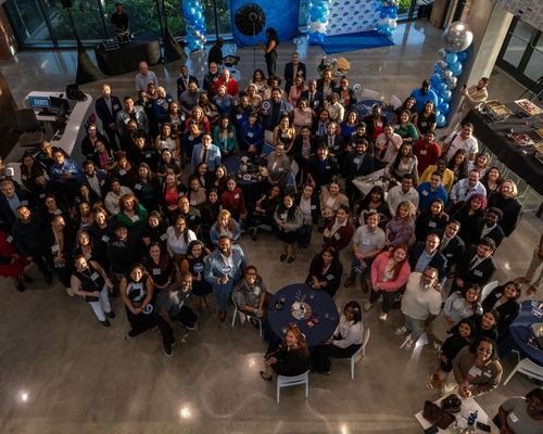 Staff, graduate students, new graduate students, and faculty smile at the new graduate scholars reception at the university of houston-downtown in houston, texas