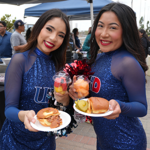 Two students in blue sequined outfits with the words 