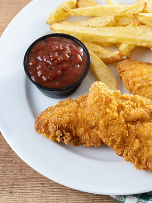 Chicken tenders, container of ketchup, and fries on a plate.