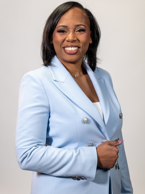 Graduate student at Marilyn Davies College of Business and member of Bayou's Best at the University of Houston-Downtown, Jessica McCraw smiles is a periwinkle colored suit. 