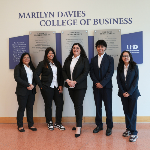 Five Ted Bauer Undergraduate Business Scholars wear professional suits from The C. T. Bauer Foundation in the lobby of the Marilyn Davies College of Business at the University of Houston-Downtown in Downtown Houston